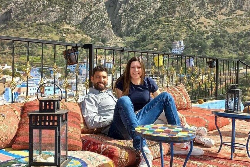 Un couple est assis sur un canapé coloré, avec un paysage montagneux en arrière-plan. 4