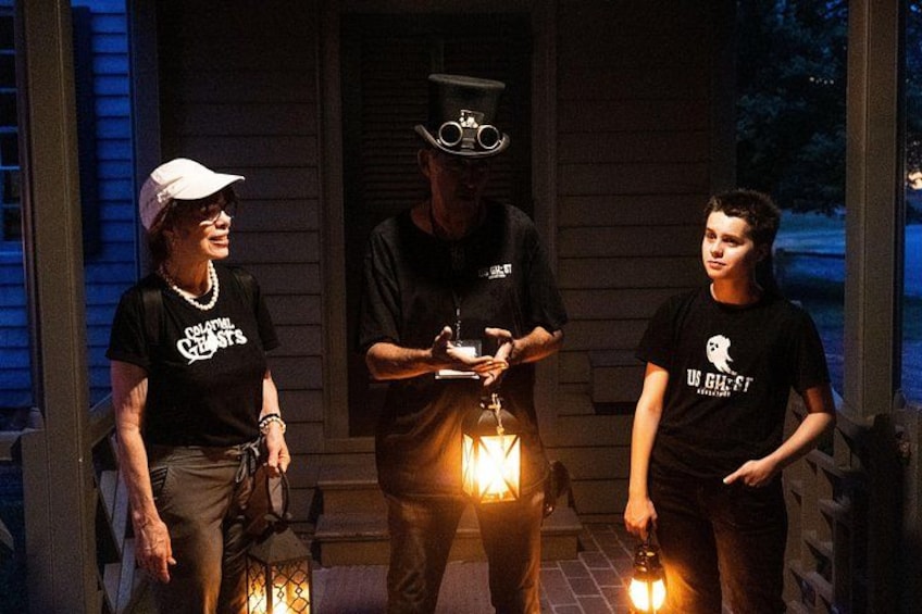 Three people on a porch with a lantern. 2