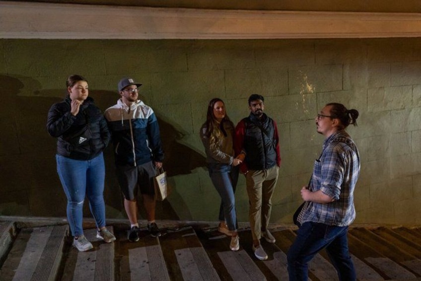 A group of people standing on a wooden platform in an underground setting. 4