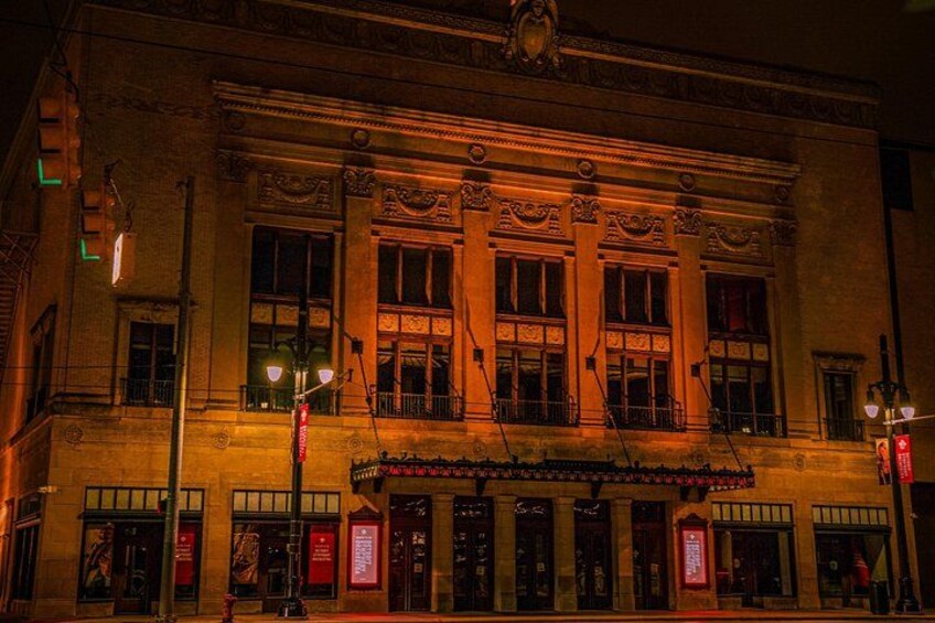 A historic building with ornate architecture, illuminated windows, and a marquee sign. 5