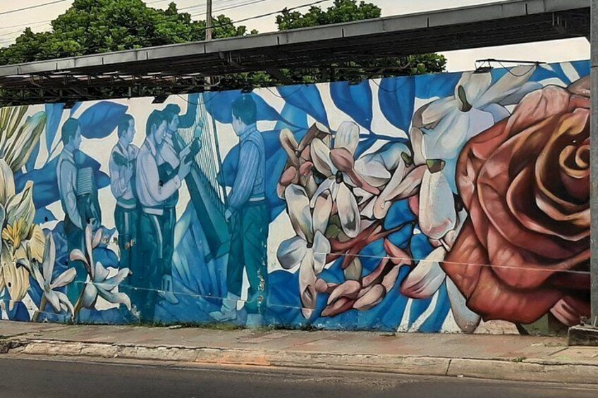 A mural with people and flowers on a wall. 3