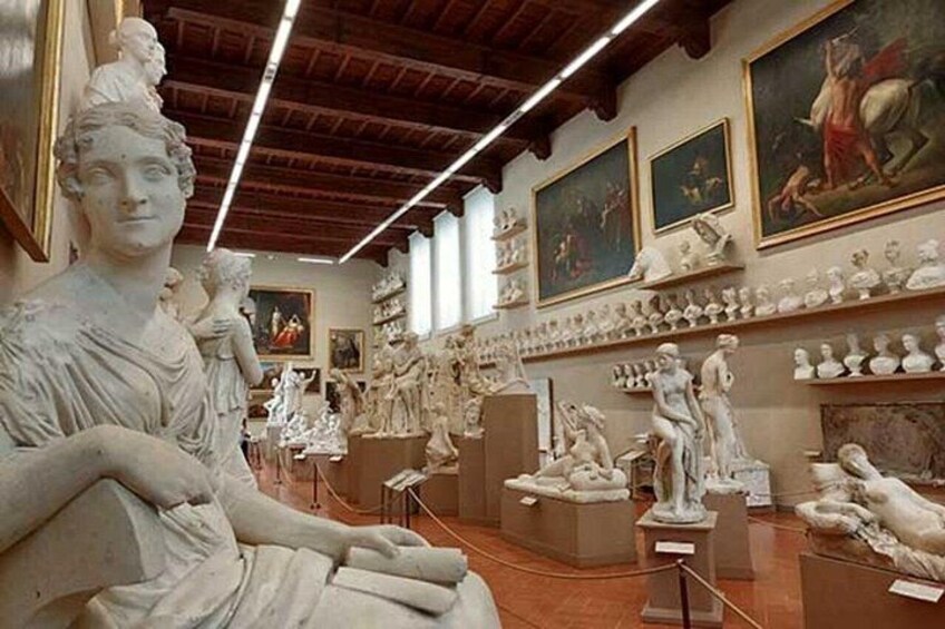 A museum with marble sculptures and paintings on display. 4