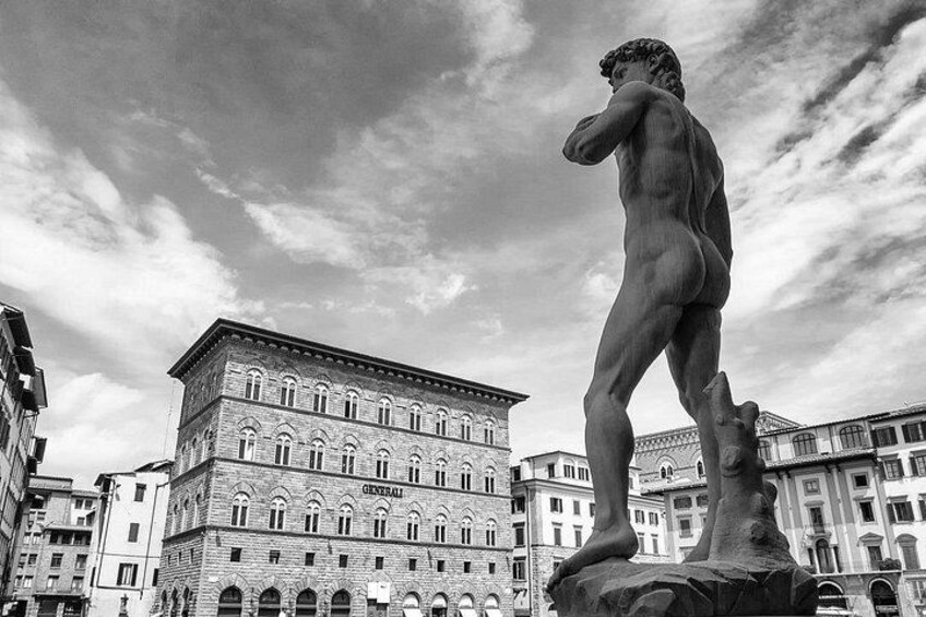 A classical statue in a square with historic buildings in the background. 2