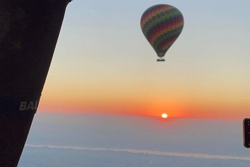 A hot air balloon, a sunset, and a clear sky. 5