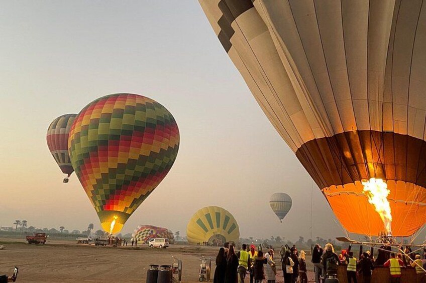 Hot air balloons, a crowd of people, and a clear sky. 4