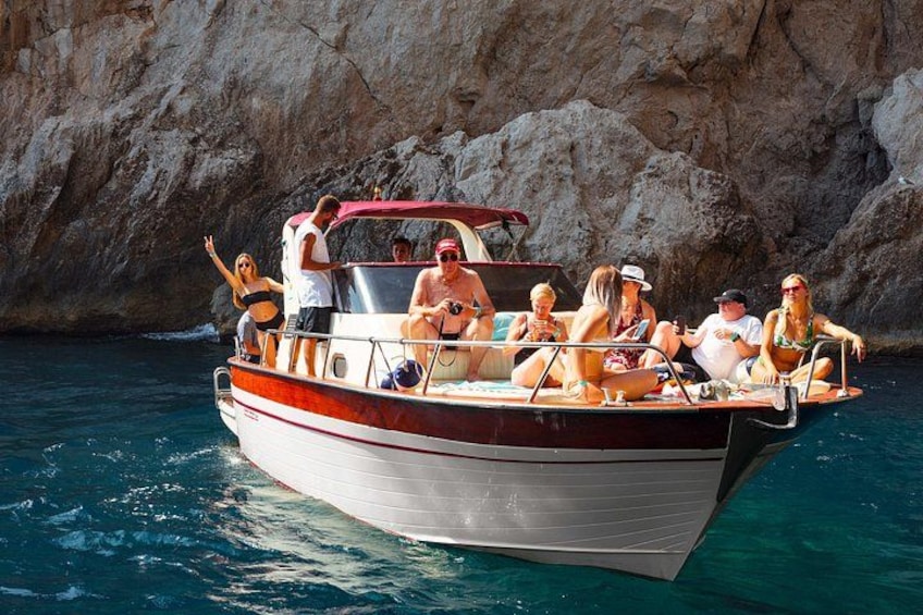 A boat with people on it near a rocky coastline. 2
