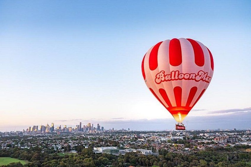 Een luchtballon met de tekst 'Balloon Man' er op, die boven een stadsbeeld vliegt. 2