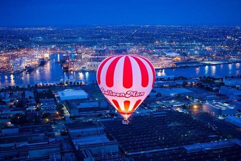 A cityscape at dusk with a hot air balloon labeled 'Balloon Man' flying over a river. 2