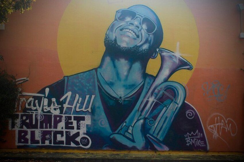 Un mural de una persona tocando una trompeta, con el texto 'TRUMPET BLACK' y 'RAY HILL'. 4