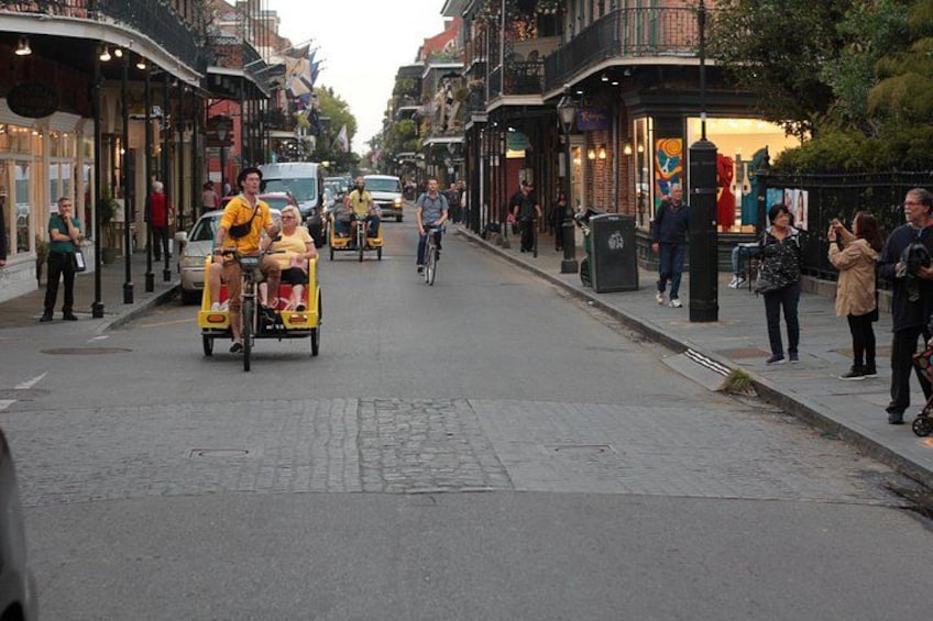 Una calle con gente andando en bicicleta y caminando. 3