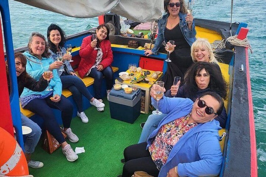 Un grupo de personas en un barco, con una mesa preparada para comer y beber. 5
