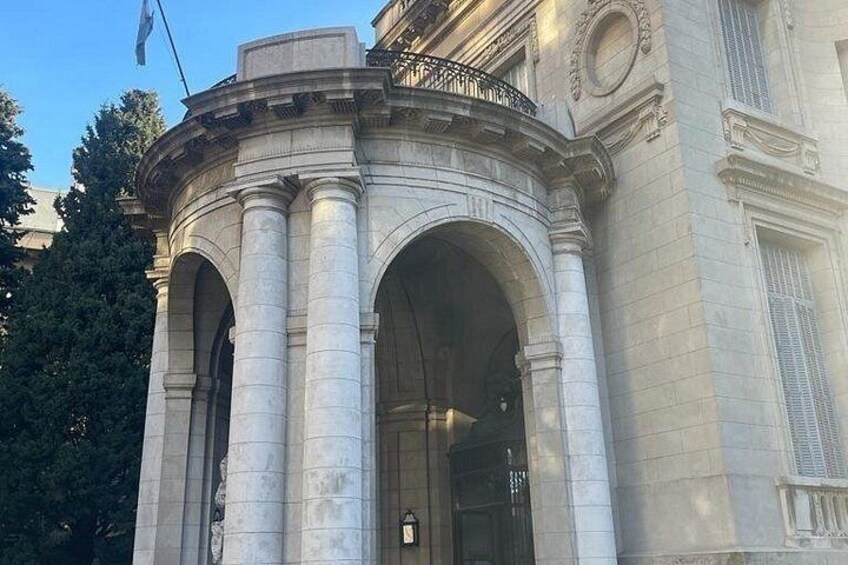 A classical building with a large arched entrance and columns. 3