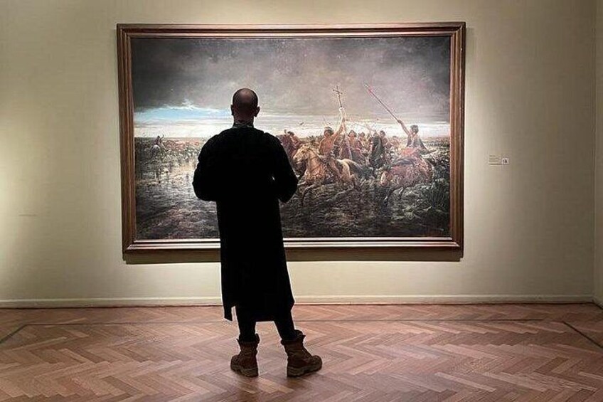 A person standing in front of a large painting in an art gallery. 5