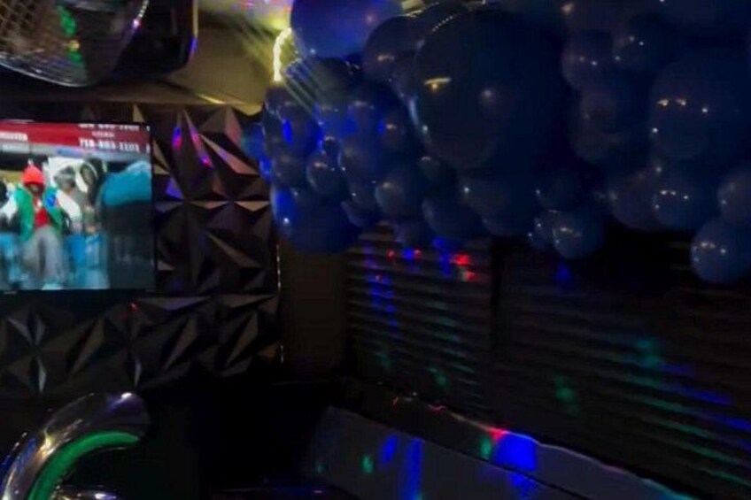 A room with a patterned wall, a blue balloon decoration, and a television screen. 4