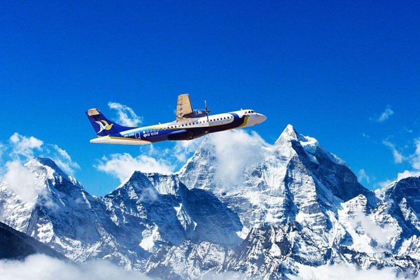 An airplane flying over snow-capped mountains. 1