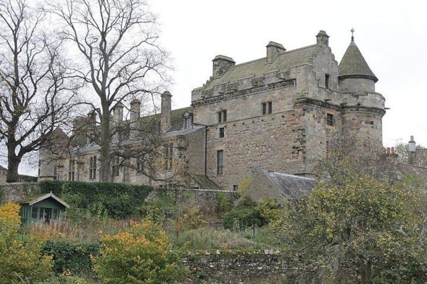 A historic stone castle with turrets and a small adjacent building. 1