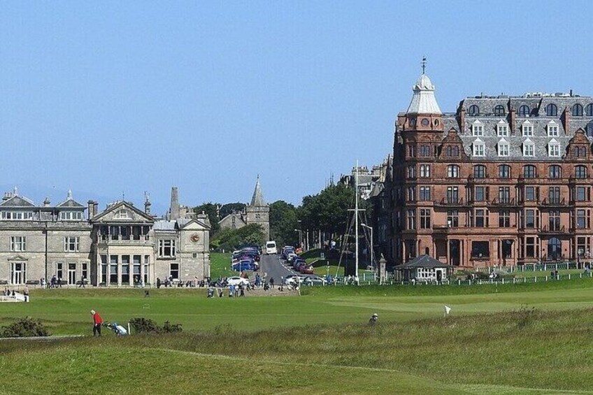 A golf course with a large building and a bus in the background. 5
