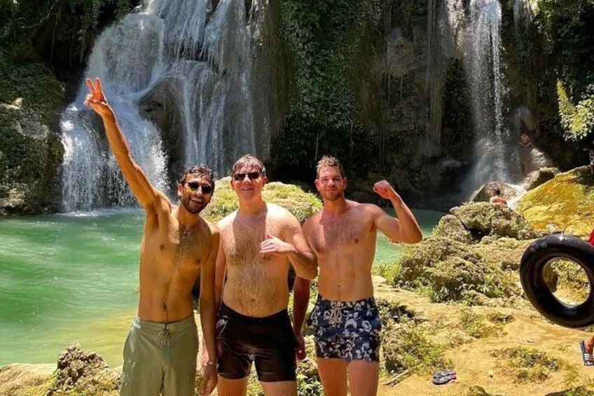 Three people posing in front of a waterfall. 5