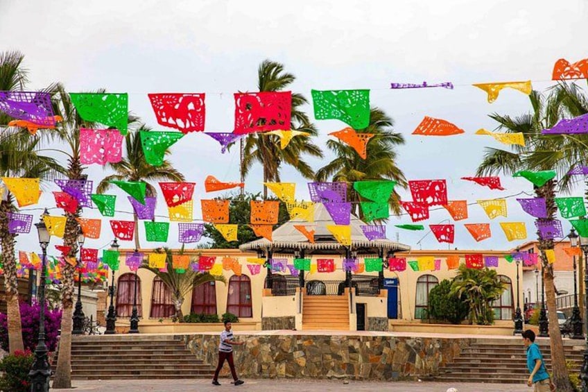A building with arched windows and a stone facade, decorated with colorful flags. 4