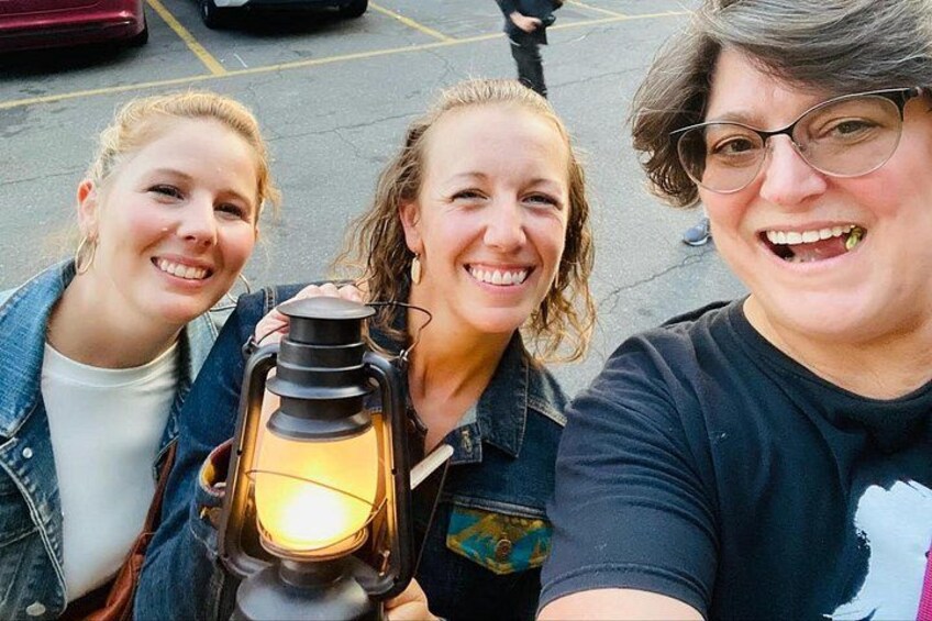 Three people holding a lantern. 3