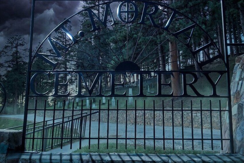 A cemetery gate with a metal arch and the words 'NEWPORT CEMETERY' engraved on it. 4