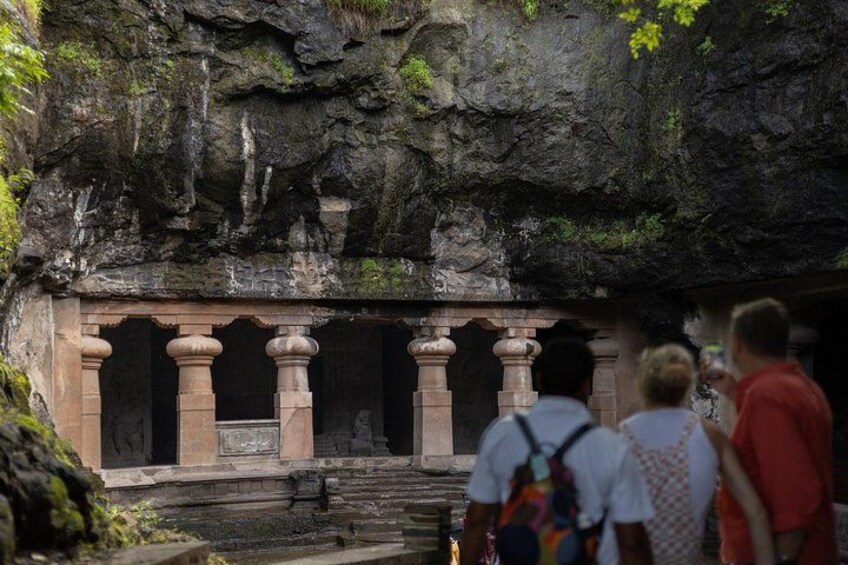 A rock-cut temple entrance with columns and a staircase leading up. 1