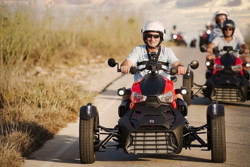 Eine Person fährt mit einem Quad auf einem befestigten Weg, der von Gras gesäumt ist. 3