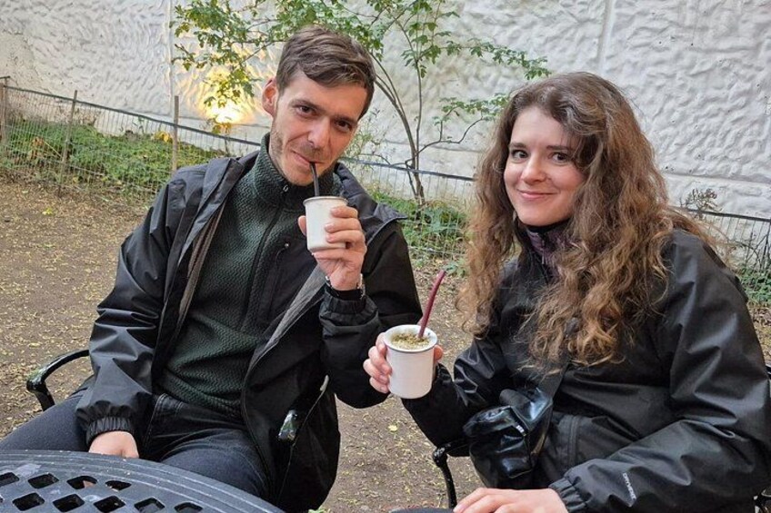 Deux personnes sont assises sur un banc à l’extérieur et tiennent chacune une tasse avec une paille. 5