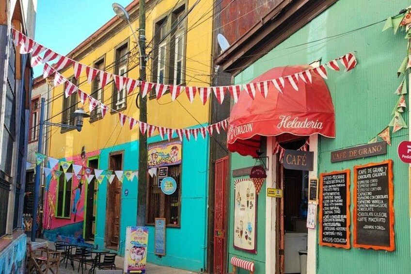 A colorful street with a café named 'Kheladerya' and a café de grano. 1