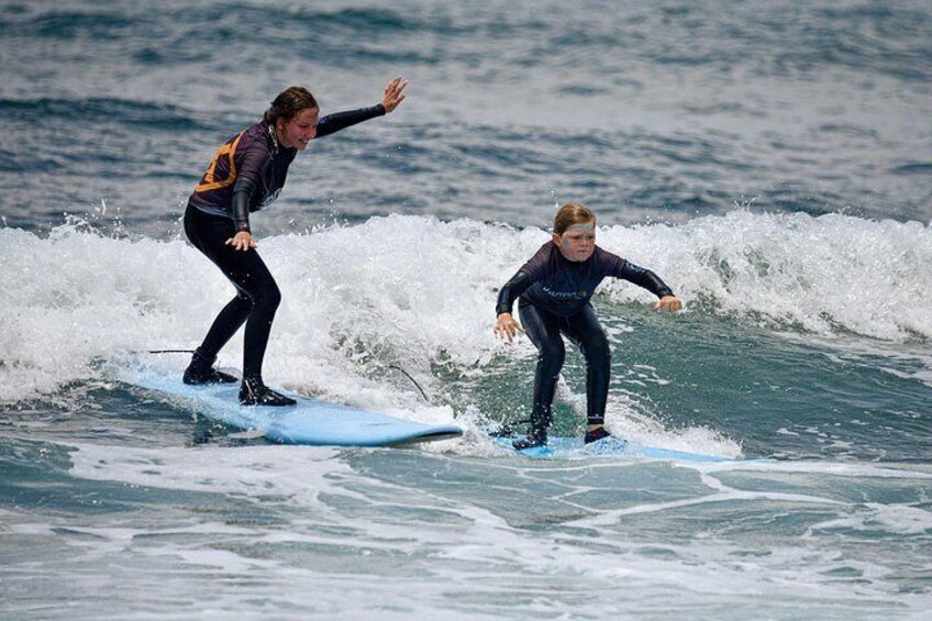 Two people surfing on a wave in the ocean. 5