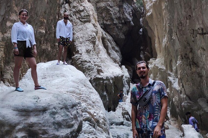 Un canyon roccioso con persone in piedi su una grande formazione rocciosa. 2