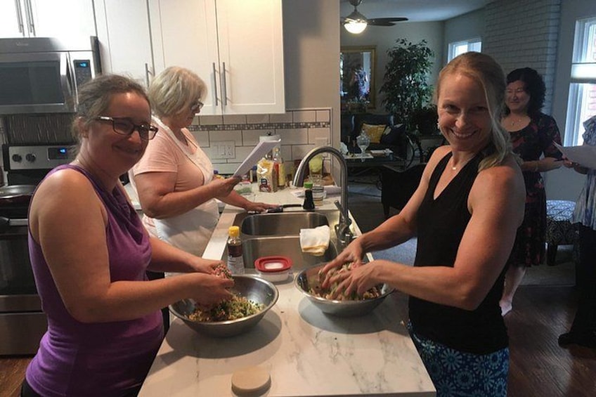 Tres mujeres preparando comida en una cocina con electrodomésticos modernos y una encimera de mármol. 1