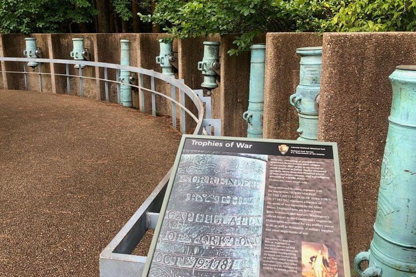 A historical exhibit with cannons and a sign titled 'Tropes of War'. 2