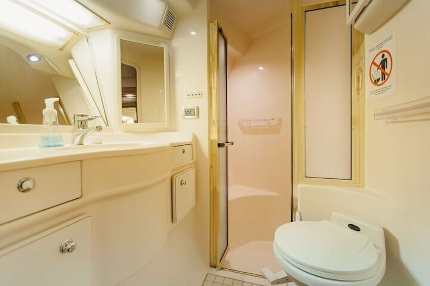 A bathroom with a white sink, mirror, and toilet. 1