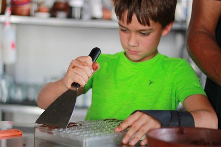 A person using a large knife to cut something on a cutting board. 5
