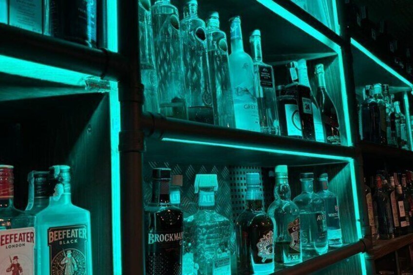 Una estantería con diversas botellas de licores, incluyendo marcas como Grey Goose y Beckmann. 4