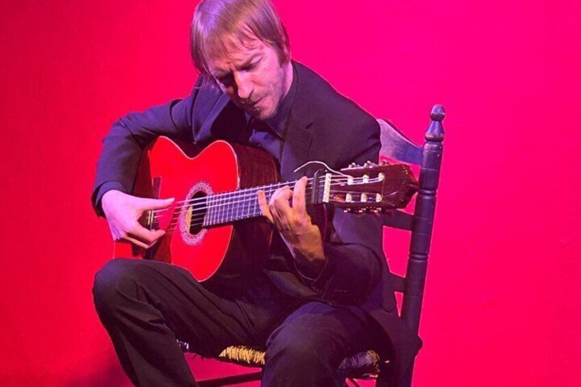 Una persona tocando una guitarra roja. 3