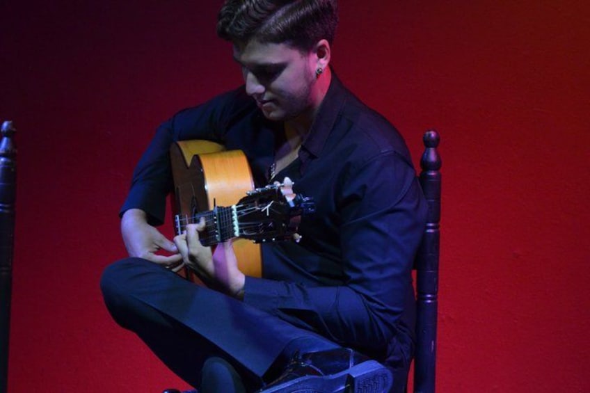A person playing an acoustic guitar. 5