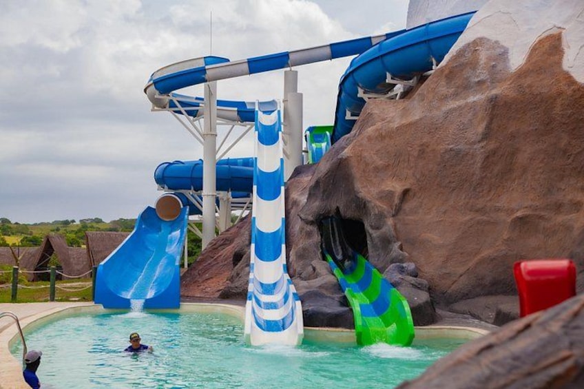 A water park with slides and a large rock formation. 2