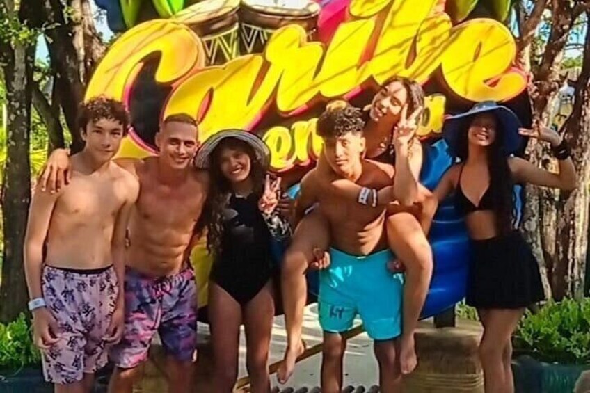 A group of people posing in front of a colorful sign. 5