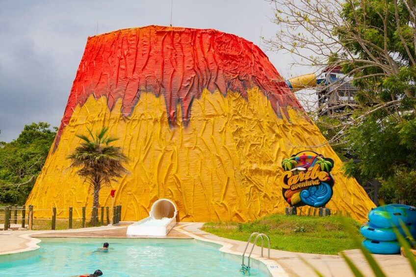 A large inflatable slide with a tropical design, a pool, and a palm tree. 2