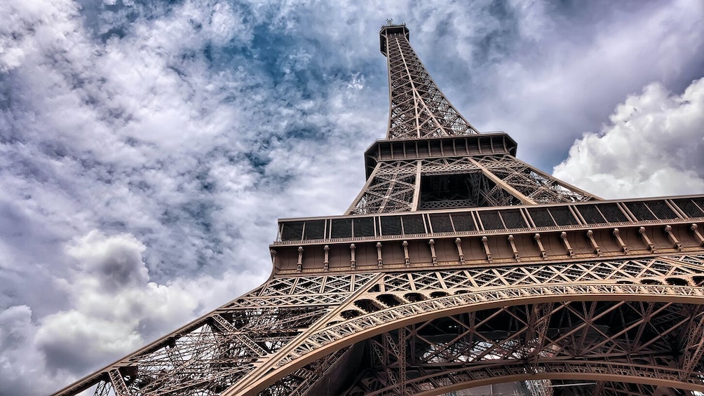 The Eiffel Tower's intricate iron lattice structure against a cloudy sky. 1