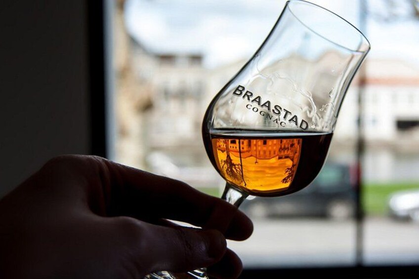 En hand som håller i ett ölglas med texten ”BRAASTAD COGNAC” på. 4
