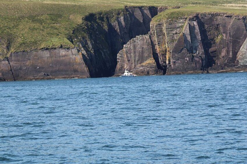 A coastal cliff with a boat near the edge. 2