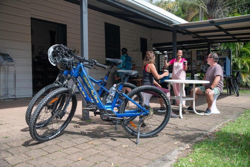 A blue mountain bike parked outside a building with a covered patio area. 5