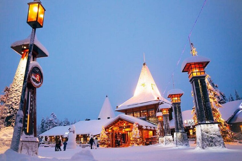 A snow-covered lodge with a distinctive conical roof, illuminated by warm lights, surrounded by snow-laden trees. 5