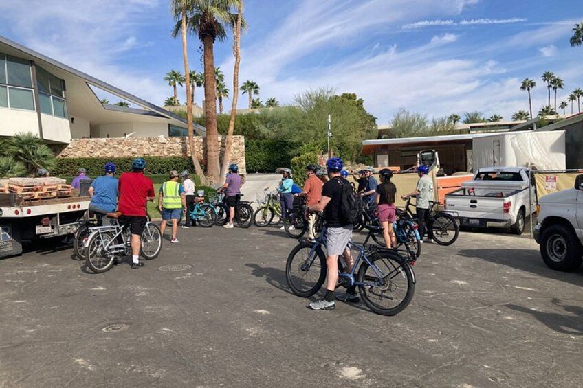 Een groep mensen met fietsen staat rond een vrachtwagen, mogelijk spullen aan het laden of lossen. 3