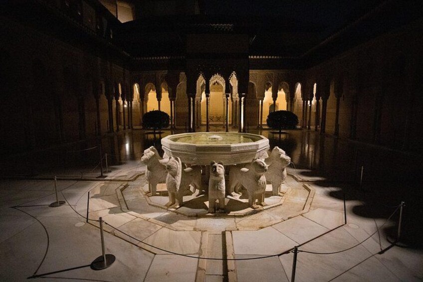 A courtyard with a central fountain, surrounded by stone statues and arches. 3