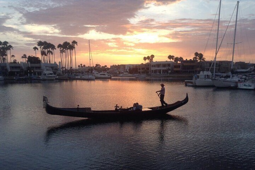 Una gondola su acque calme con un tramonto sullo sfondo. 2