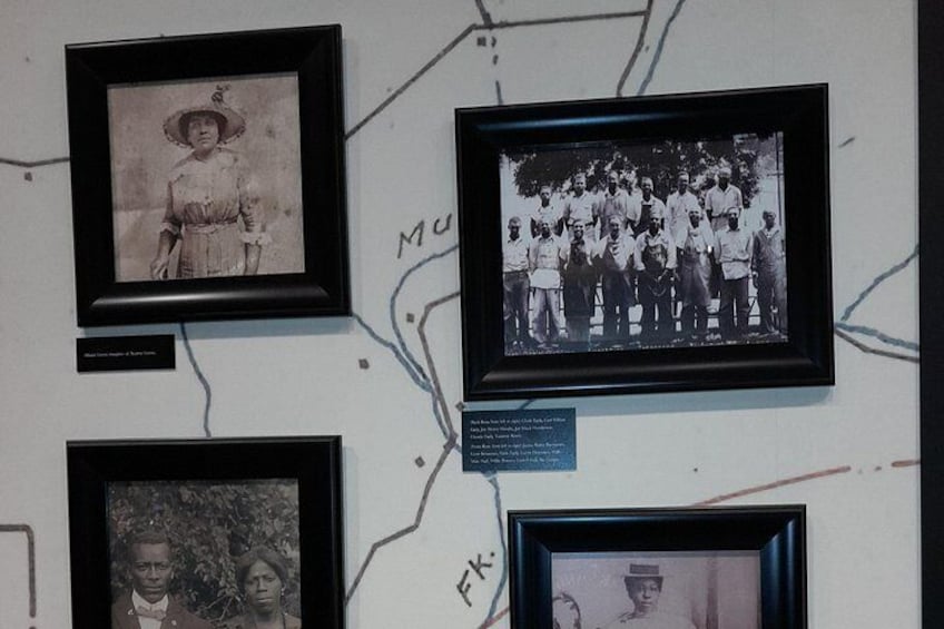 A wall with framed photographs, including a group photo and individual portraits. 4